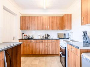 a kitchen with wooden cabinets and white appliances at 2 Bed in Holt oc-73518 in Holt +8 photos
