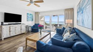 a living room with a blue couch and a tv at Blue Nine 2 in Panama City Beach