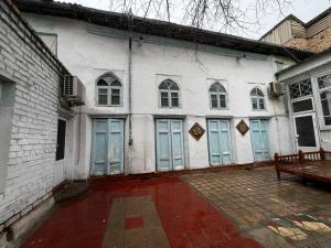 a white building with blue doors and a bench at Hotel Zukhritdin in Bukhara