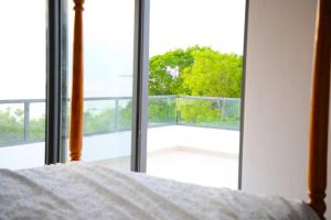 a bedroom with a bed and a view of a balcony at Bustani villa in Zanzibar City