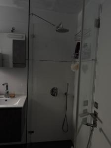 a bathroom with a shower and a sink at The Urban Suite in Petaẖ Tiqwa