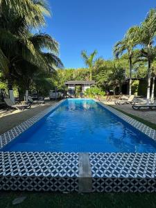 a large blue swimming pool with palm trees at Bacalar 102 Hotel in Bacalar