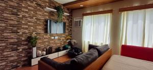 a living room with a couch and a brick wall at Rye Lees Place in Bacolod