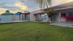 a house with a yard with a hammock on it at Pousada Coxim in Coxim