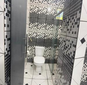 a bathroom with a white toilet in a shower at Pousada Coxim in Coxim +11 photos