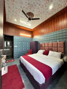 a bedroom with a large bed with a ceiling fan at Bella Vista Hotel & Home Stay in Mussoorie