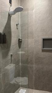 a shower with a glass door in a bathroom at Suítes House Refúgio Fortim in Fortim +57 photos