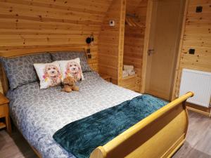 a bedroom with a bed with a teddy bear on it at Thelmas Lodge in Llanelli