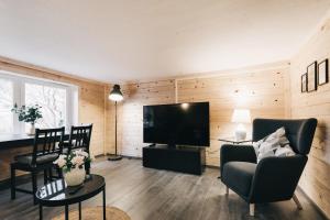 a living room with a television and chairs and a table at Kleines Häuschen in der Oberlausitz in Löbau +19 photos