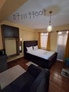 a hotel room with a bed and a couch at Lora's Haven Homes - Kisii Studio2 in Kisii