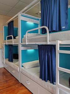 a room with bunk beds with blue walls at Albergue A Ponte Ribadeo in Ribadeo