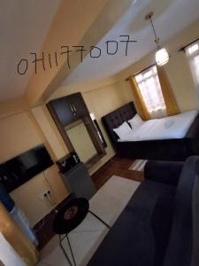 a small living room with a bed and a couch at Lora's Haven Homes - Kisii Studio2 in Kisii