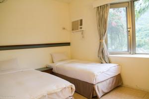 a room with two beds and a window at Ayawan Hot Spring Resort in Wenquan