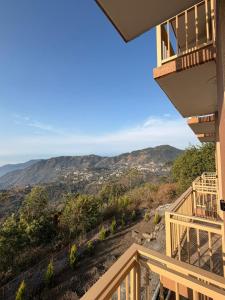 a balcony of a house with a view of the mountains at Dual Lake in Bhīm Tāl