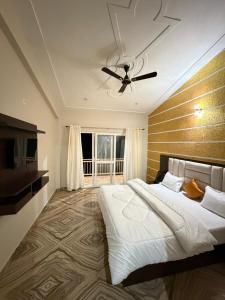 a bedroom with a large bed and a ceiling fan at Dual Lake in Bhīm Tāl