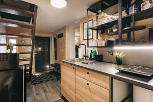a kitchen with wooden cabinets and a black refrigerator at Kleines Häuschen in der Oberlausitz in Löbau