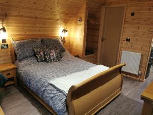 a bedroom with a bed in a wooden room at Lodge 2 in Llanelli