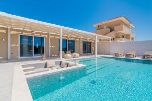 a swimming pool in front of a house at Spartakos Villa Resort - Slow Living Retreat collections With Private Pools in Planos