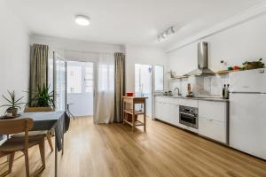 a kitchen with white cabinets and a table in a room at VV Gara Galdar in Gáldar