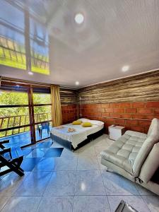 a bedroom with a bed and a couch in a room at Cabañas San Jose in Doradal