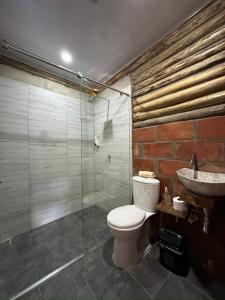 a bathroom with a toilet and a shower and a sink at Cabañas San Jose in Doradal