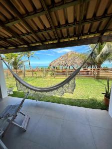 a hammock in a house with a view of the ocean at OCA Caraíva in Caraíva