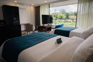 a hotel room with two beds and a television at Hotel Lagoon in Rionegro +41 photos