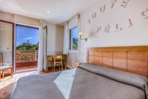 a bedroom with a bed and a desk and a window at Hotel Leku Eder in San Sebastián +34 photos