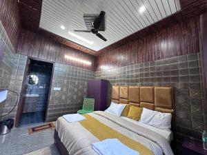 a bedroom with a large bed with a ceiling fan at Bella Vista Hotel & Home Stay in Mussoorie