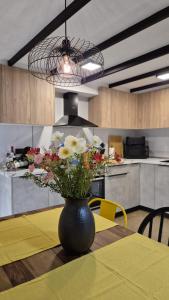 a vase with flowers on a table in a kitchen at A3 Valencia Ciudad cómodo Bajo Diseño hasta 6, wifi gratis in Valencia