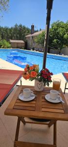 a table with two coffee cups and flowers on it at Quinta Penedo das Antas in Sertã +17 photos