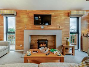 a living room with a fireplace with a tv above it at 3 Bed in Swanage oc-94067 in Swanage