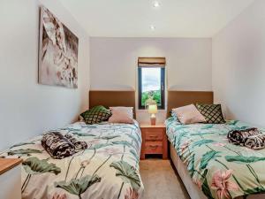 a bedroom with two beds and a window at 3 Bed in Swanage oc-94067 in Swanage