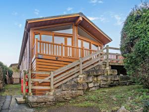 a small cabin with a wooden staircase leading up to it at 3 Bed in Swanage oc-94067 in Swanage