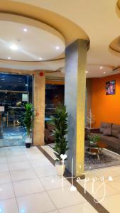 a lobby with potted plants in a building at Najmat Sabbabah Furnished Units in Hail
