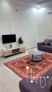 a living room with a couch and a table at Najmat Sabbabah Furnished Units in Hail