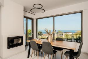 a dining room with a table and chairs and a fireplace at Astarte Villas - Casa De Sun Private Villa with Pool in Zakynthos