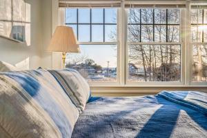 a bedroom with a bed and a large window at Town & Tide Home for 8 in Kennebunkport