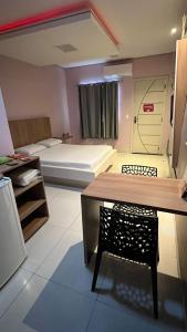 a room with a bed and a table with a chair at Luxu's Motel in Tucano