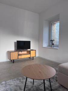 a living room with a tv and a coffee table at Apartment Krajinka in Cheb