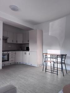 a kitchen with white cabinets and a table and chairs at Apartment Krajinka in Cheb