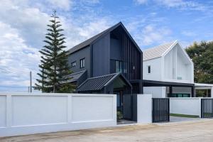 a black and white house with a white fence at Norden Barn B&B in Chiang Mai