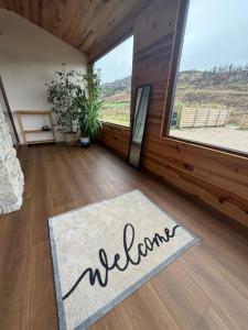 a welcome rug on the floor in a room with a window at Sessaigh lake studio in Dunfanaghy +5 photos