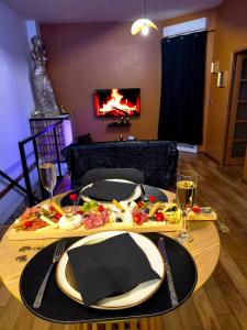 a table with two plates of food and wine glasses at Loveroom LovaLova in Reims