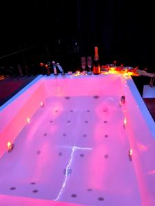 a hot tub with pink lights on it at Loveroom LovaLova in Reims