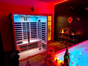 a red room with a bath tub with a large window at Loveroom LovaLova in Reims