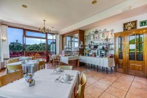 a restaurant with tables and chairs and a large window at Hotel Leku Eder in San Sebastián