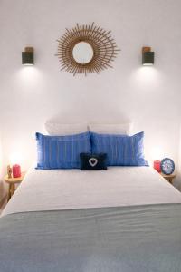 a bedroom with a bed with blue pillows and a mirror at Un Chalet au Verger-Dog friendly-Jacuzzi & Massages in Conteville