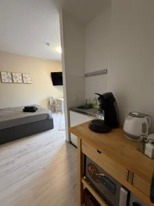 a small room with a bed and a kitchen with a microwave at SchaeBu! 7 Apartment Work and Travel am Altmarkt in Cottbus