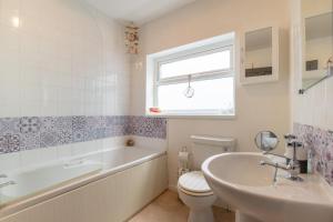 a bathroom with a toilet and a tub and a sink at 3 Bed in Mumbles oc-hh1223 in The Mumbles +14 photos